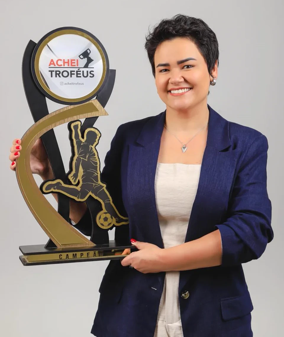 Representante da Achei Troféus segurando um troféu personalizado